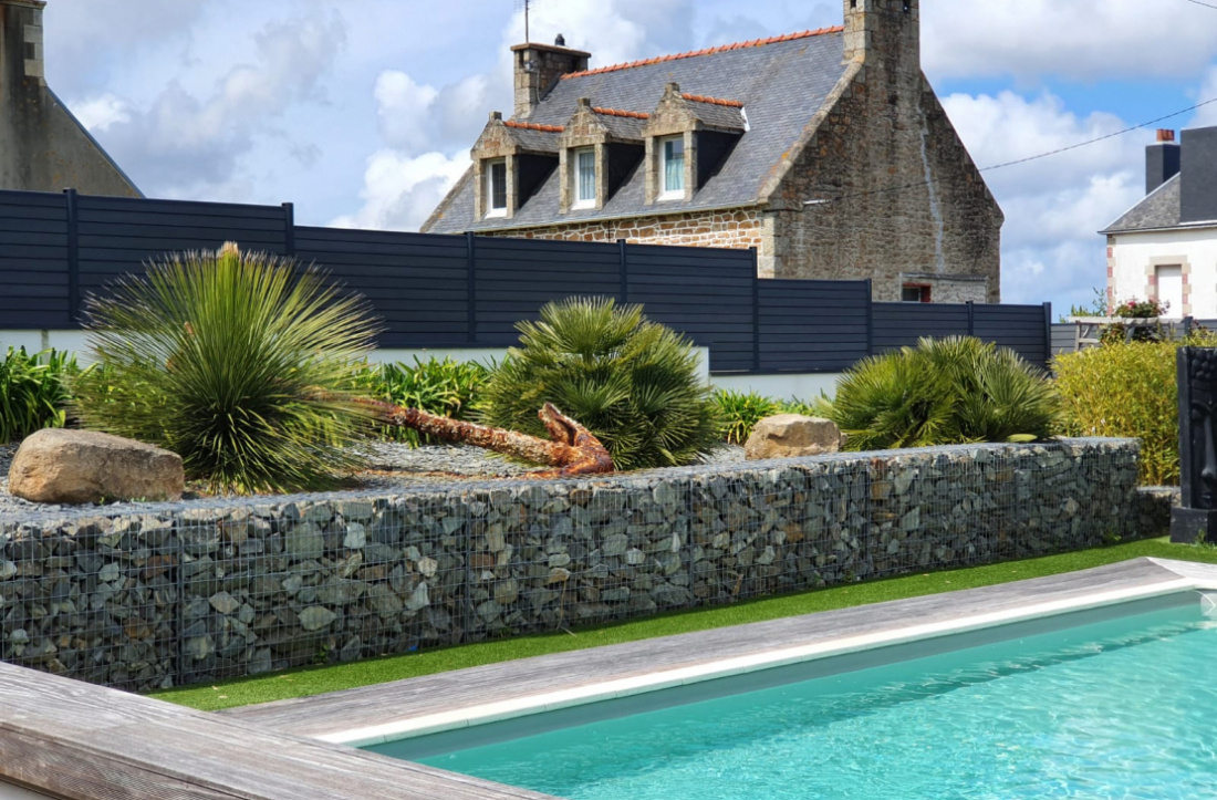 Extérieur avec clôture gabion et plantes tropicales 